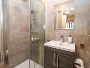 a bathroom with a sink and a shower at Swing Bridge Cottage in Brandesburton +19 photos