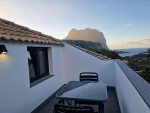 a table and chairs on a balcony with a view of the ocean at Stay Lombinho in Porto da Cruz