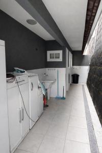 a kitchen with white cabinets and a sink in a room at Casa Aconchegante com Vista pertinho do Centro Histórico in Petrópolis +18 photos