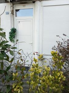 a white door of a house with yellow flowers in front at Grand appartement spacieux au centre de Chambéry, gare à pied in Chambéry