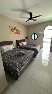 a bedroom with two beds and a ceiling fan at Homestay Babah - Private Chalet in Malacca