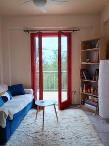 a living room with a couch and a sliding glass door at Helios-Selene Villa in Lévktron