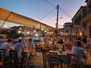 a group of people sitting at tables in an outdoor restaurant at Helios-Selene Villa in Lévktron