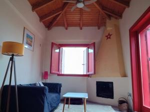 a living room with a blue couch and a window at Helios-Selene Villa in Lévktron