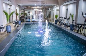 a pool with a fountain in the middle of a building at Résidence PLAZZAET OUAGA 2000 in Ouagadougou