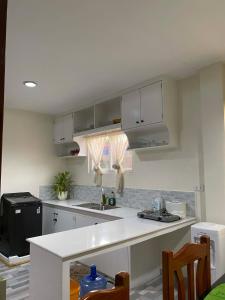 a kitchen with white cabinets and a white counter top at Tiny Home fronting Alburquerque Church in Alburquerque