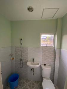 a bathroom with a toilet and a sink at Tiny Home fronting Alburquerque Church in Alburquerque