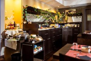 a restaurant kitchen with a large kitchen with food at UNAHOTELS Villa dei Platani Foligno in Foligno