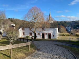 a white house with a fence in front of it at Halleluja mit Burgblick in Hellenthal