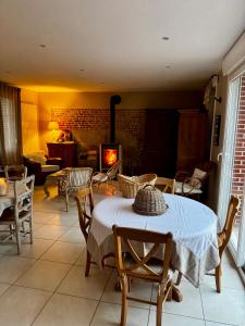 a living room with a table and chairs and a fireplace at La Suite du 12 Maison d hôtes in Brie