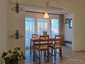 a dining room with a wooden table and chairs at Corddora Apartman in Mezőkövesd +28 photos