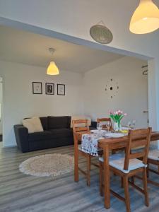 a living room with a table and chairs and a couch at Corddora Apartman in Mezőkövesd