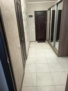an empty hallway with a door and a tile floor at SweetHome in Ternopil