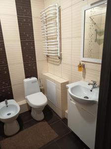 a bathroom with a toilet and a sink at SweetHome in Ternopil
