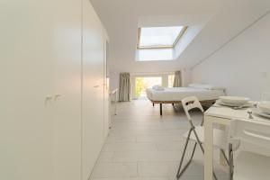 ein Schlafzimmer mit einem Bett, einem Tisch und einem Stuhl in der Unterkunft Still Loft in Coslada