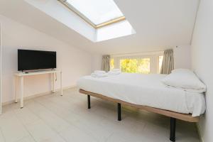 ein Schlafzimmer mit Bett und Flachbildfernseher in der Unterkunft Still Loft in Coslada
