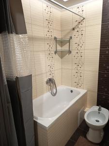 a bathroom with a bath tub and a toilet at SweetHome in Ternopil