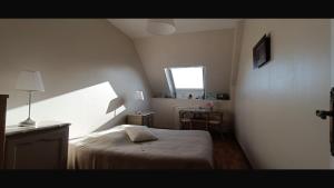 a bedroom with a bed and a window and a table at Caux-Breizh in Rohan