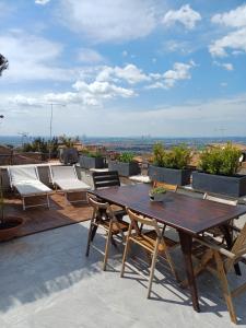 a wooden table and chairs on a roof at Il Campanile in Tivoli