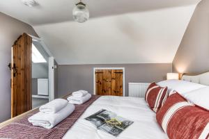 a bedroom with a bed with towels on it at Old Stable Cottage in Kingham