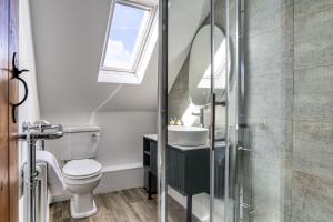 a bathroom with a toilet and a sink and a window at Old Stable Cottage in Kingham +29 photos