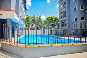 a fence around a swimming pool next to a building at Savana Abode-Nakuru CBD in Nakuru