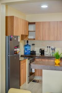 a kitchen with a stainless steel refrigerator and wooden cabinets at Savana Abode-Nakuru CBD in Nakuru