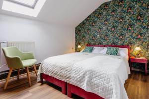 a bedroom with a bed and a green wall at Familia in Český Krumlov