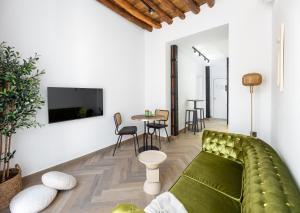 a living room with a green couch and a table at Apartamentos El Marqués in Granada