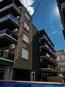 an apartment building with balconies and a pool at Blue Sea Nest in Paralia Katerinis