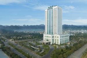 a tall white building in a city with a street at Pullman Ninh Binh in Ninh Binh