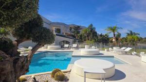 a swimming pool with white chairs and a house at My Place B&B in Carini