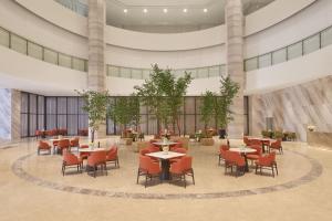 a lobby with tables and chairs in a building at Pullman Ninh Binh in Ninh Binh