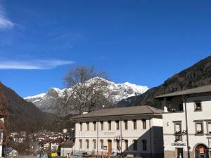 a white building with snow covered mountains in the background at Casa Vacanze Everest in Paluzza