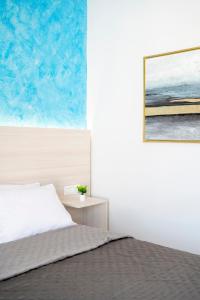 a bedroom with a bed and a painting on the wall at Azure Edge - Seafront View - Beach Stay in Tigaki