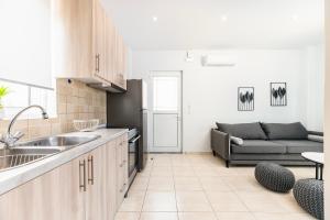 a kitchen and a living room with a couch at Azure Edge - Seafront View - Beach Stay in Tigaki