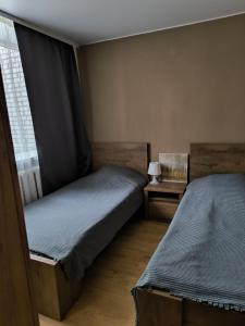 two twin beds in a room with a window at Apartment GLORIA in Narva-Jõesuu +2 photos