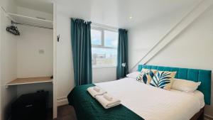 a bedroom with a bed with a blue headboard and a window at Town Lodge in Newquay