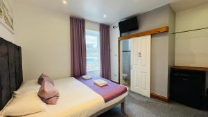 a bedroom with a bed and a large window at Town Lodge in Newquay