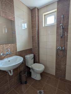 a bathroom with a toilet and a sink and a shower at Hotel Poli in Blagoevgrad