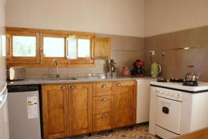 a kitchen with wooden cabinets and a white stove top oven at El Rancho , casa de huéspedes in Tupungato