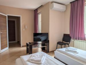 a hotel room with two beds and a television at Hotel Poli in Blagoevgrad