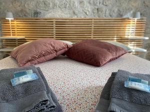 a bed with two pillows and two towels on it at Appartamento Scaligeri in Venzone