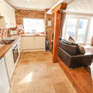 a kitchen with a black leather couch in a room at Butterswood Lakes in Goxhill