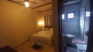 a bedroom with a bed and a toilet in a room at Pousada Girar do Sol in Nova Friburgo