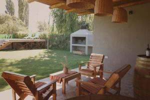 a patio with chairs and a table and a fireplace at El Rancho , casa de huéspedes in Tupungato