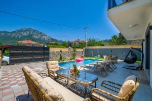 a patio with a table and chairs and a pool at Villa Huzur in Fethiye