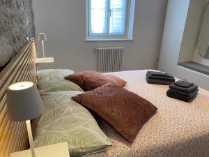 a bed with pillows and a lamp in a room at Appartamento Scaligeri in Venzone