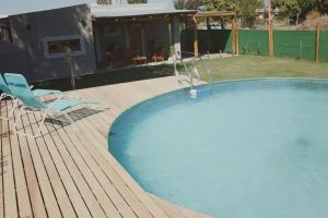 a swimming pool with two chairs and a house at El Rancho , casa de huéspedes in Tupungato