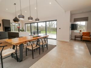 a kitchen and dining room with a wooden table and chairs at Cloneytrace Mines in Ballymena
